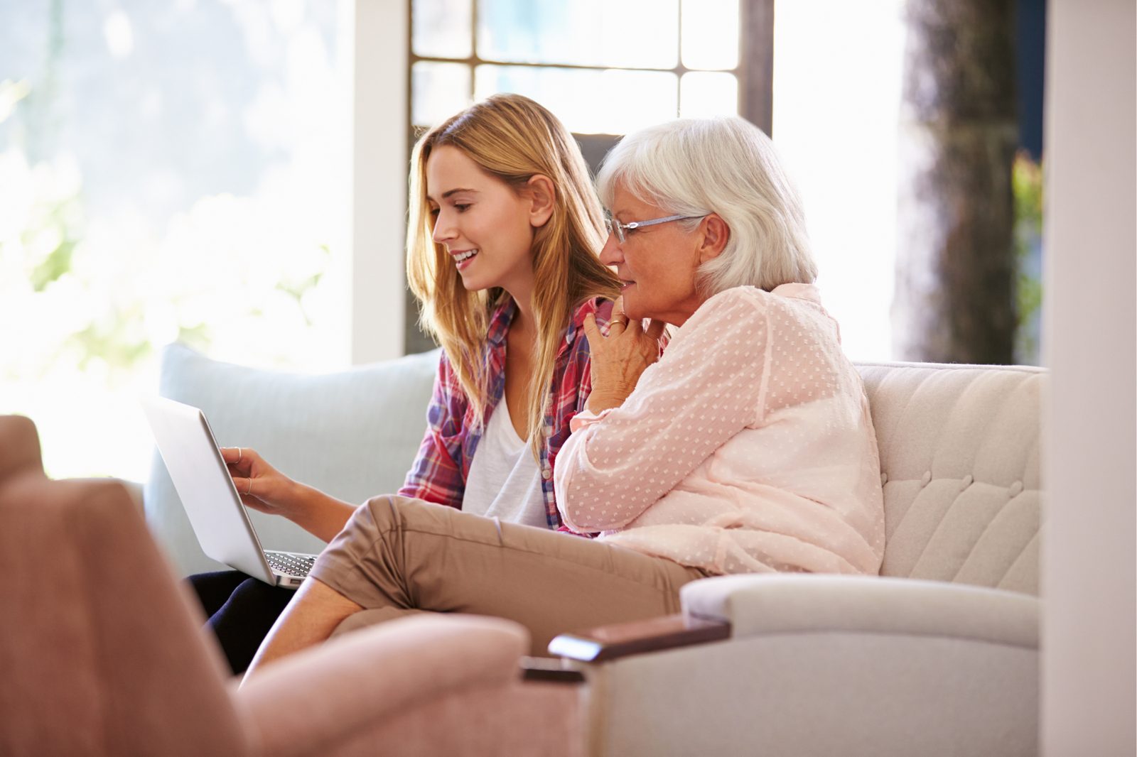 An older adult and her daughter reviewing senior living options together on a laptop