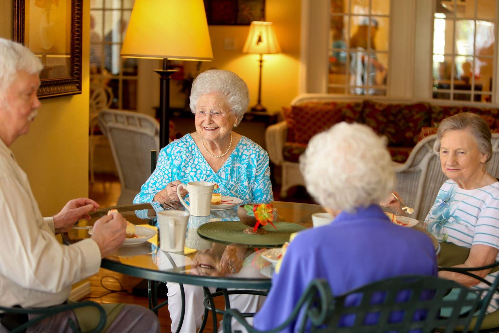 Older adults enjoying a meal and conversation together in a senior living community dining room