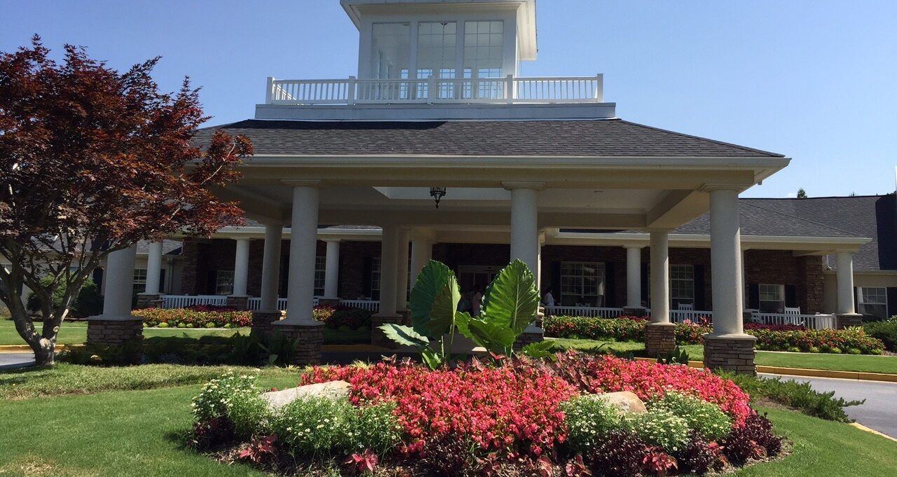 Front exterior view of a welcoming senior living community on a clear day